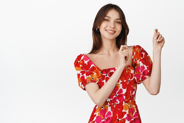 Menina morena dançando com vestido floral sorrindo e rindo conceito de celebração e festivais de fundo branco