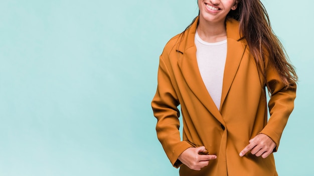 Menina morena sorridente posando com casaco