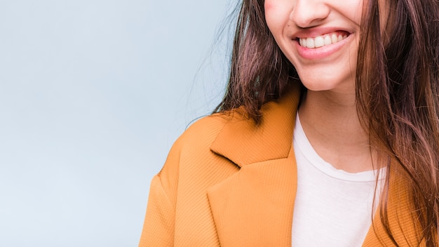 Menina morena sorridente posando com casaco