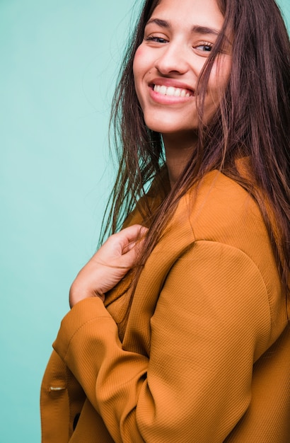 Menina morena sorridente posando com casaco