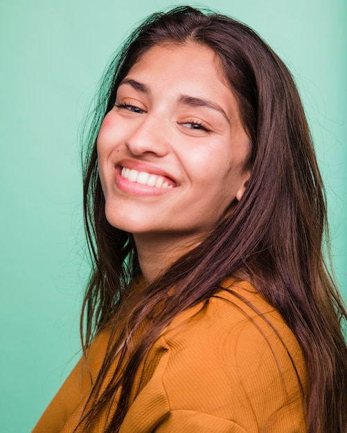 Menina morena sorridente posando com casaco