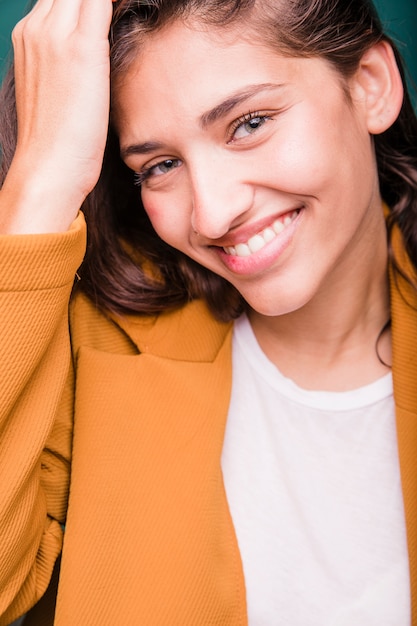 Menina morena sorridente posando com casaco