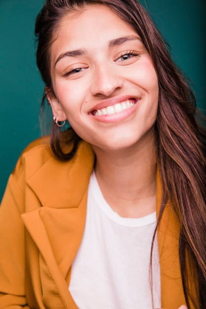 Menina morena sorridente posando com casaco