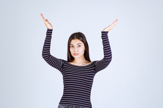 Menina mostrando a quantidade ou medidas de um produto.