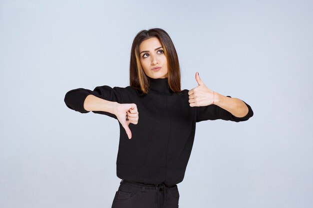 Menina mostrando sinal de cima e para baixo do polegar. Foto de alta qualidade