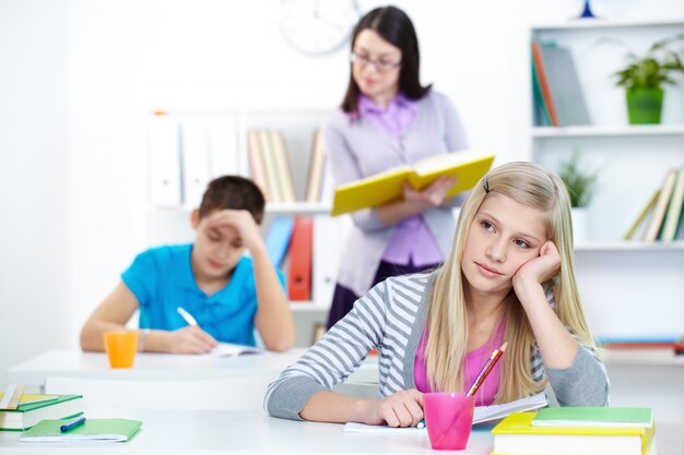 Menina na classe que pensa sobre a resposta