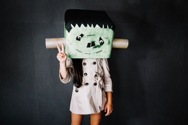 Foto grátis menina na máscara de frankenstein gesticulando a paz