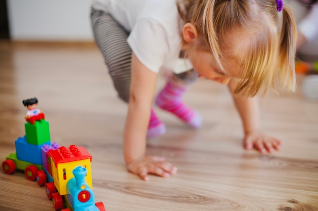 Menina no chão com brinquedos