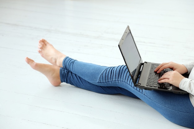 Menina no chão com um laptop