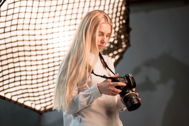 Menina no estúdio usando uma foto da câmera