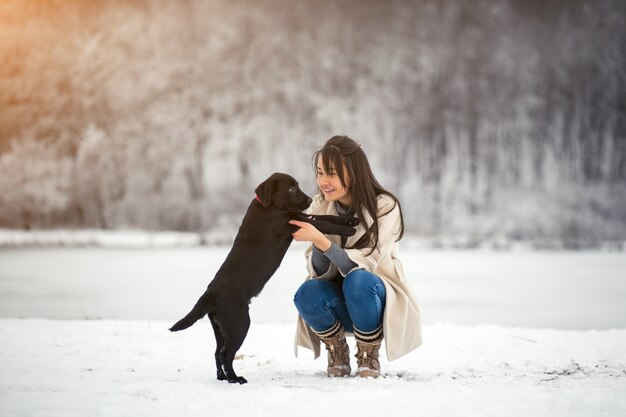 Menina no inverno brincando com cachorro