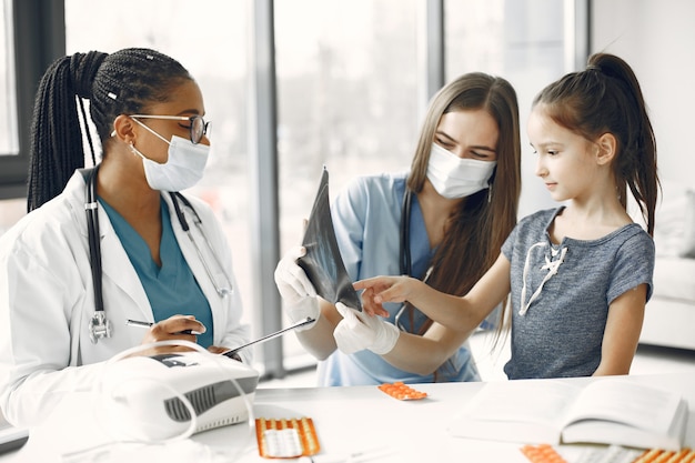 Menina no médico. Exame da criança. Médico africano.