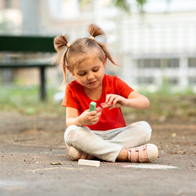 Menina no parque de desenho com giz