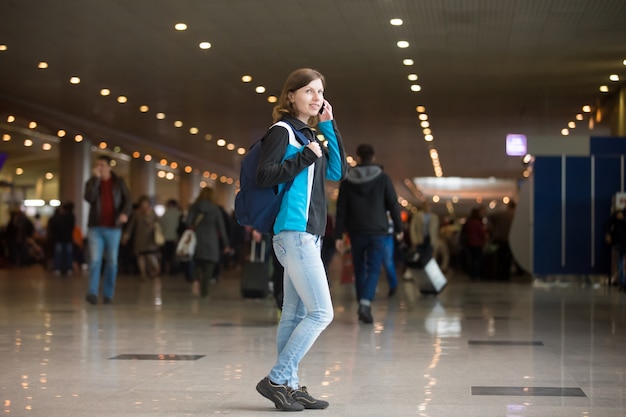 Menina no telefone no aeroporto