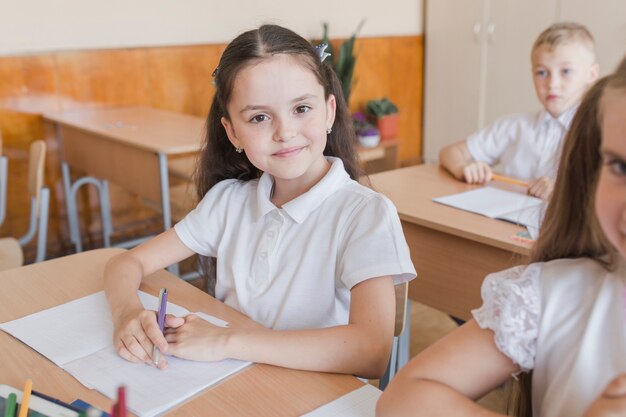 Menina, olhando câmera, durante, lição