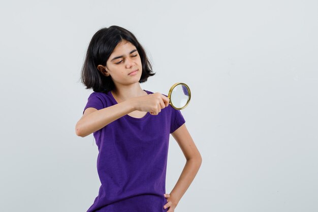 Menina olhando pela lupa em uma camiseta