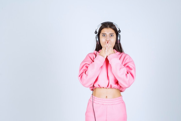 Menina ouvindo os fones de ouvido e pedindo silêncio. Foto de alta qualidade