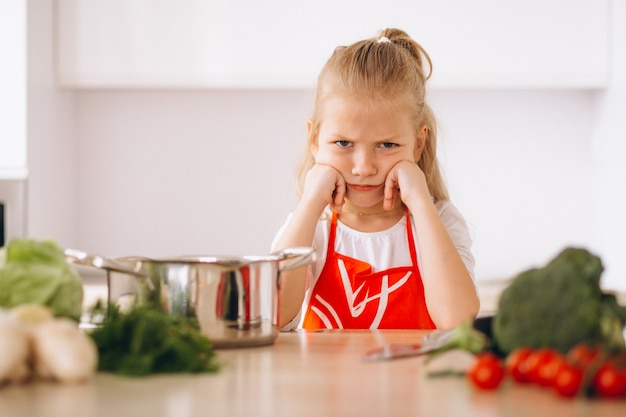 Menina pensando o que cozinhar na cozinha