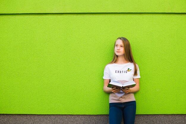 Menina pensativa com livro de texto