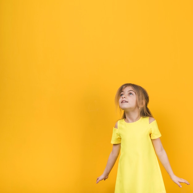 Menina pensativa no vestido amarelo