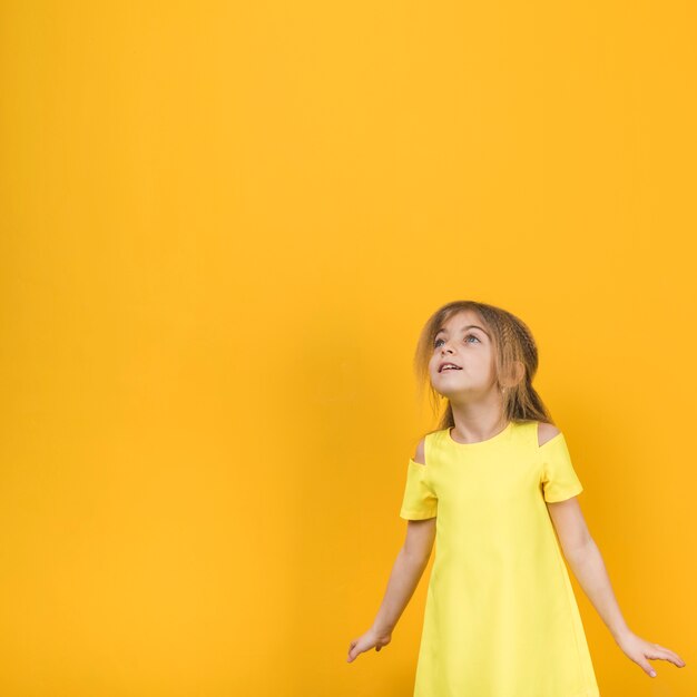 Menina pensativa no vestido amarelo