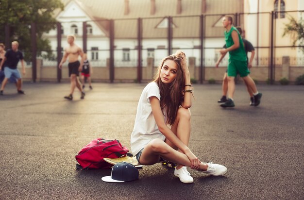 Menina pensativa sentada no skate