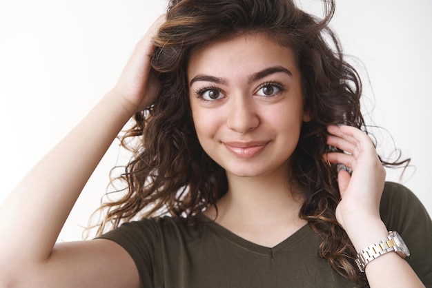 menina penteado encaracolado verificando corte de cabelo arrumando cachos perto do espelho antes de retornar namorado jantar romântico sorrindo amplamente se sentir feliz