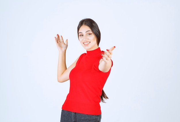 Menina percebendo e se dirigindo a alguém à frente.