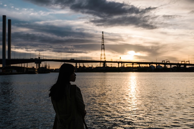 Foto grátis menina pôr do sol no mar e ponte