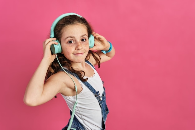 Menina posando com fones de ouvido rosa