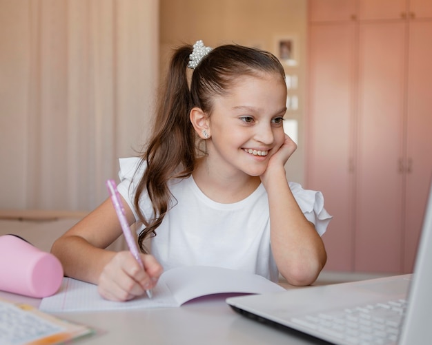 Menina prestando atenção nas aulas online em casa