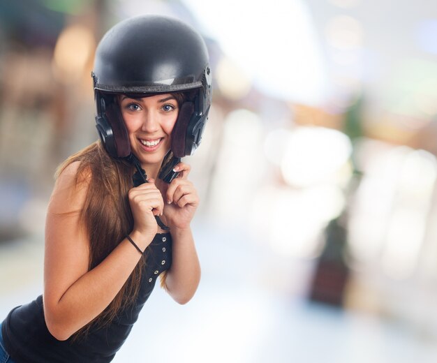 Foto grátis menina que levanta com capacete preto na cabeça.