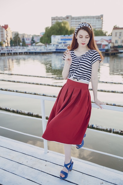 Foto grátis menina que levanta com fundo do mar em um porto