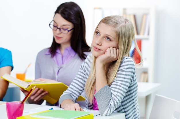 Menina que pensa na sala de aula