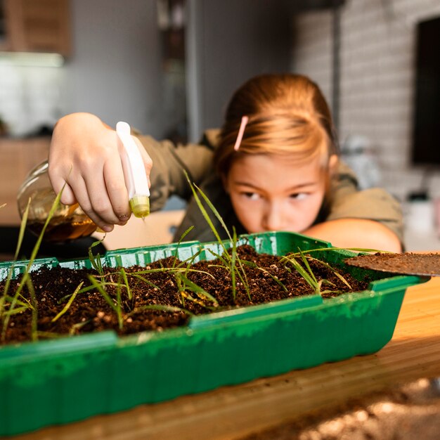 Menina regando plantações em casa