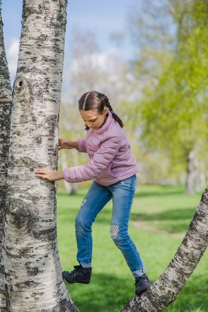 Menina relaxada brincando em uma árvore