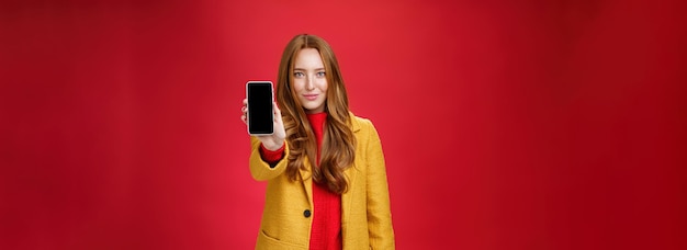 Foto grátis menina ruiva atraente e estilosa com olhar confiante e sorriso seguro puxando o celular