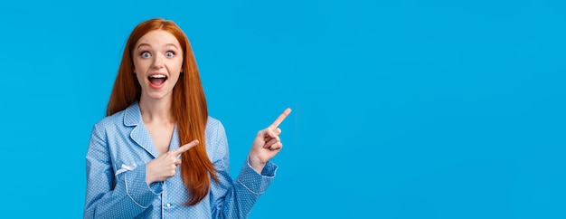 Foto grátis menina ruiva bonita e divertida oprimida em roupas de dormir gritando animada e espantada apontando para cima