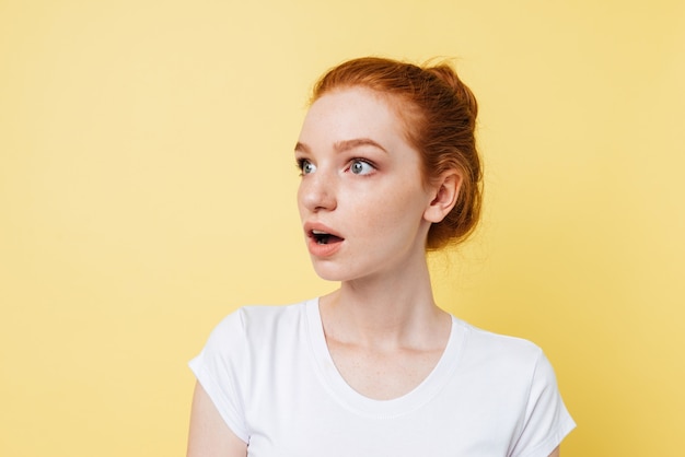 Menina ruiva chocada olhando para longe