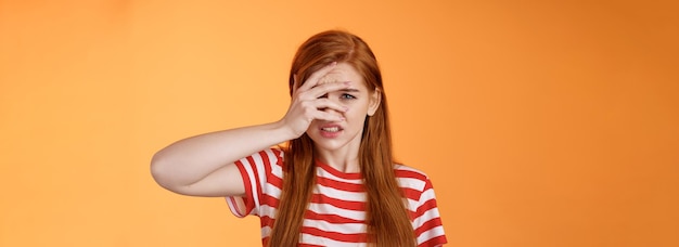 Foto grátis menina ruiva inquieta com pena de situação ruim tentando não parecer horrível amigo ferido aversão aversão antipatia