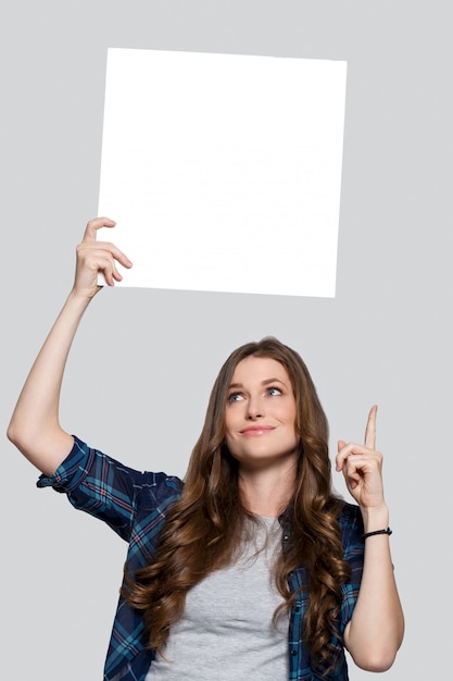 Menina segurando cartaz branco