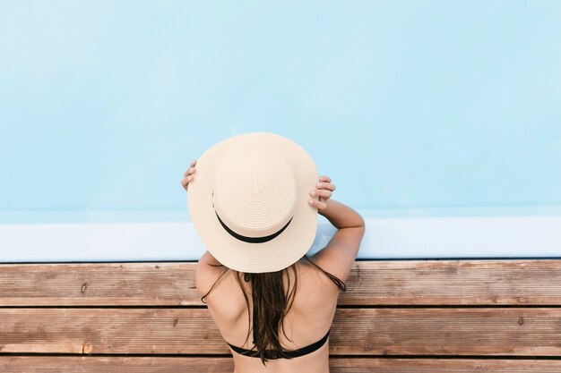 Menina, segurando, chapéu, piscina vizinha