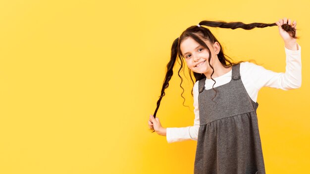 Menina, segurando, dela, pigtails, cópia-espaço