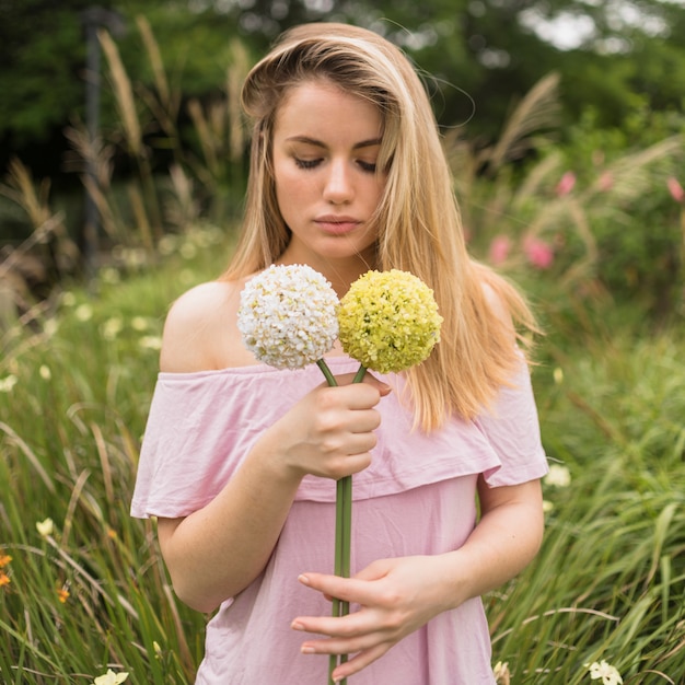 Menina, segurando, flores brilhantes, parque