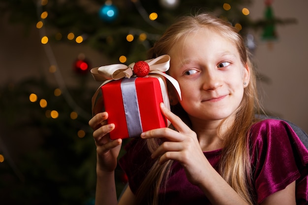 Menina segurando presentes de natal nas mãos, feliz ano novo