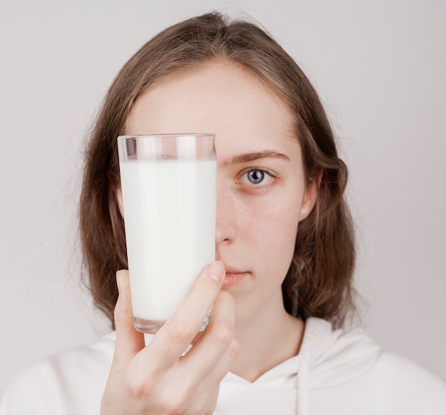 Foto grátis menina segurando um copo de leite fresco