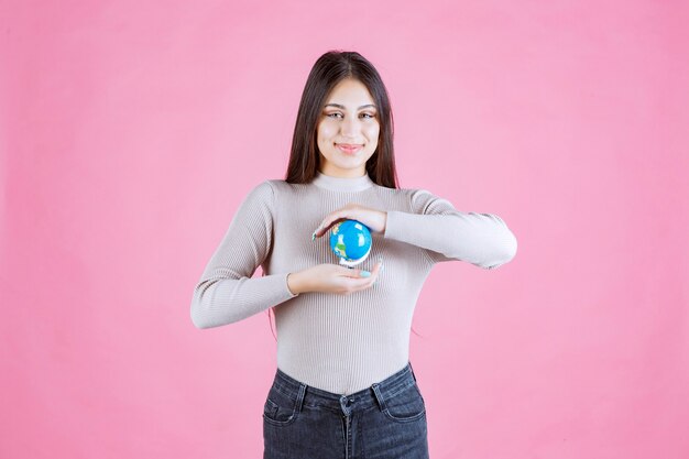 Menina segurando um globo entre as mãos