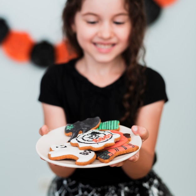 Foto grátis menina segurando um prato com biscoitos