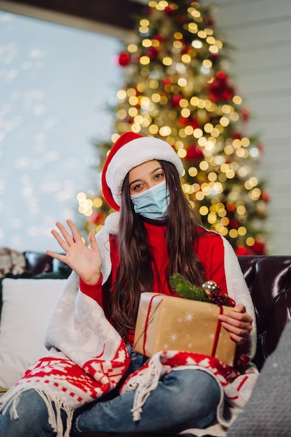 Menina segurando um presente de Natal na véspera de ano novo.