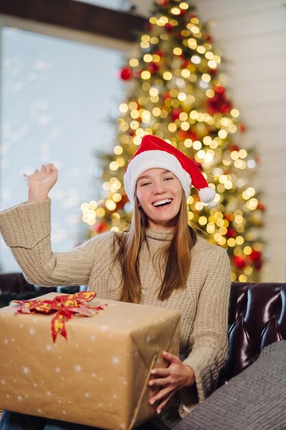 Menina segurando um presente de Natal na véspera de ano novo.